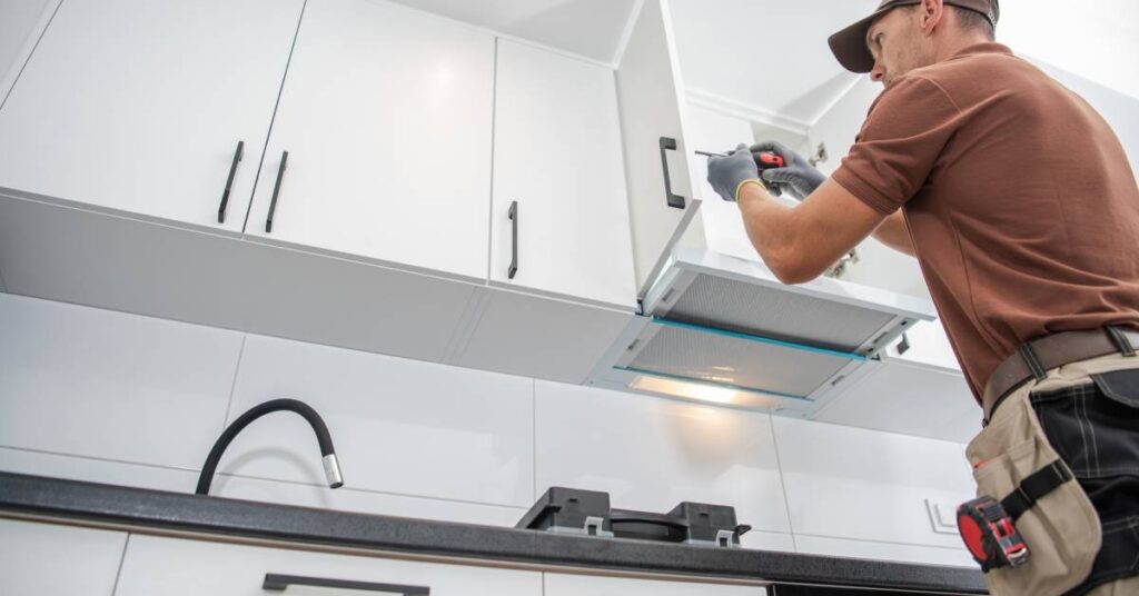 A professional contractor installing the finishing touches on his client’s custom cabinetry and kitchen remodel.